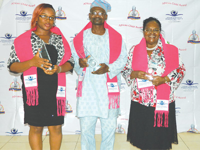 Nkem Okibe of NTA Lagos Channel 10 (left); Mr. Akin Johnson representing the Director, Lagos State Agency for Mass Education, Mrs. Amore Adefola Olufemi; Founder/Medical Director, Ikeja Medical Centre, Dr. (Mrs.) Morayo Apantaku after receiving their awards from ACSEC at the event. 