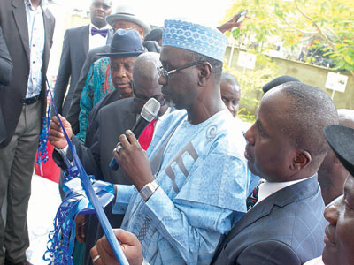 Shekarau, assisted by Azaiki, cutting the tap to commission the project. 